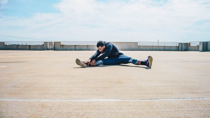 Sport Jeune homme qui fait des étirements après sa séance de sport