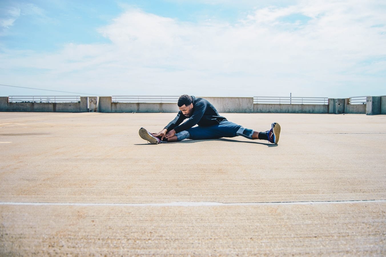 Jeune homme qui fait des étirements après sa séance de sport