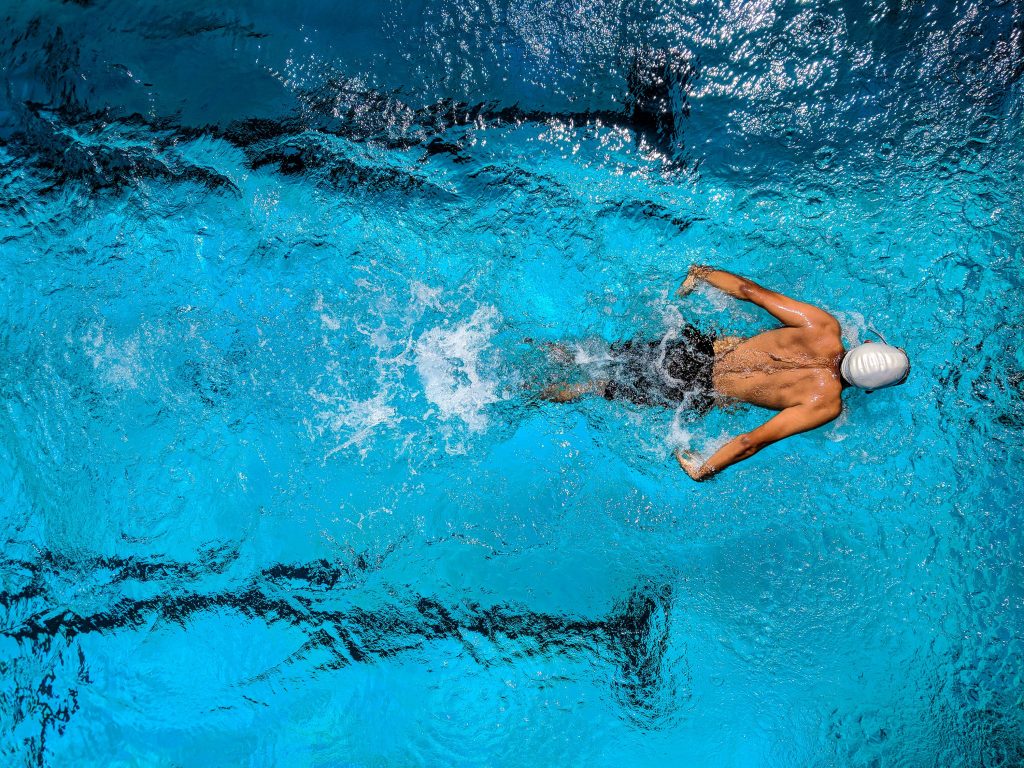 Homme qui fait des longueurs dans une piscine